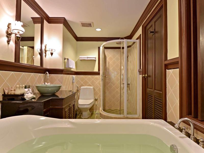Elegant bathroom with whirlpool tub, vessel sink on wooden vanity, and glass-enclosed shower.