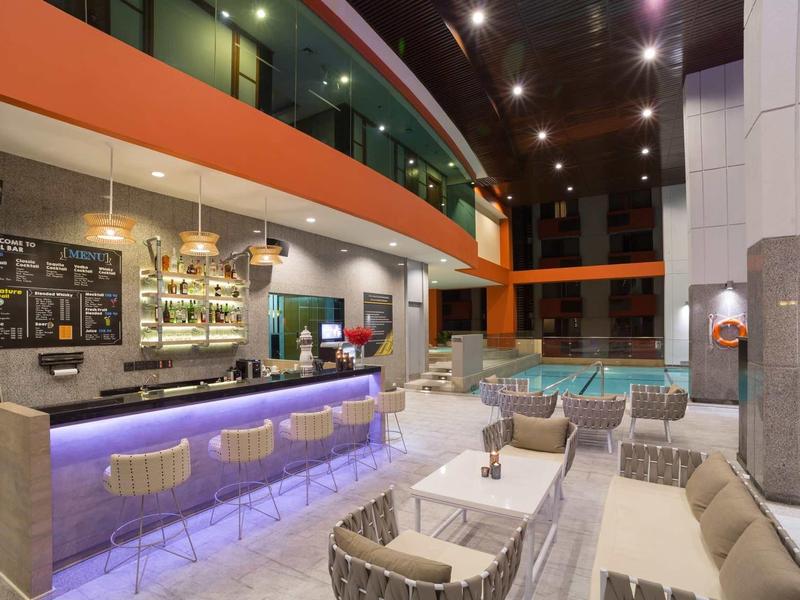 Modern hotel lobby area with illuminated bar and comfortable seating arrangements.