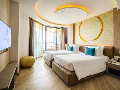 Modernes Hotelzimmer mit zwei Einzelbetten, großem Fenster und eleganter Beleuchtung.