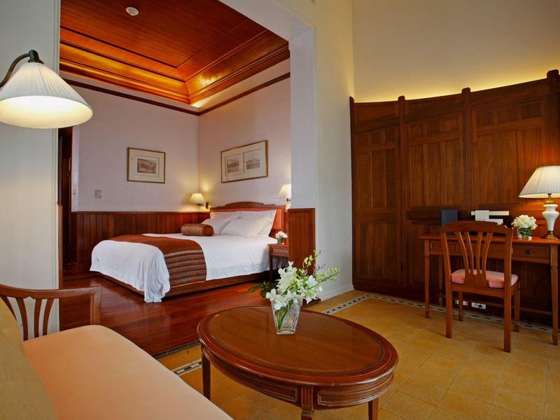 Gezellige hotelkamer met houten meubels, tweepersoonsbed, bureau en zachte verlichting.