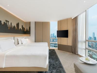 Modernes Hotelzimmer mit großem Bett, Stadtblick und minimalistischem Design.