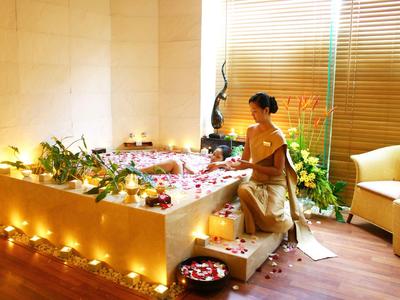 Entspannendes Spa-Bad mit Blumen und Kerzen in einer luxuriösen Umgebung.