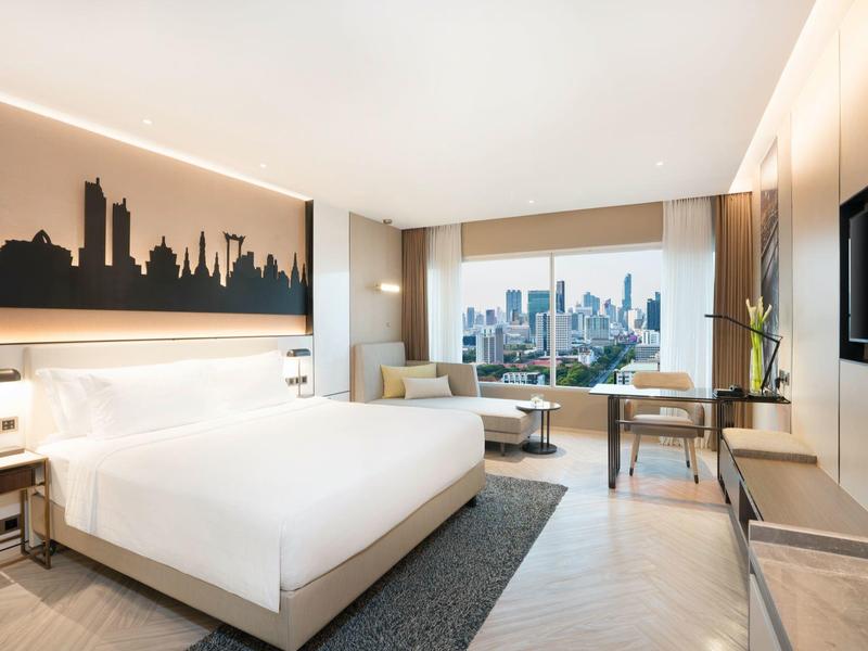 Helles Hotelzimmer mit großem Bett, Stadtblick und modernem Dekor.