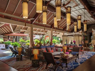 Gemütlicher Hotel-Loungesitzbereich mit dekorativen Lampen und Pflanzen im hellen, offenen Raum.