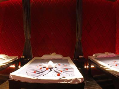 Rote Samtsitze mit dunklem Holz und weißgedeckte Tische mit Servietten und Besteck in einem Restaurant.