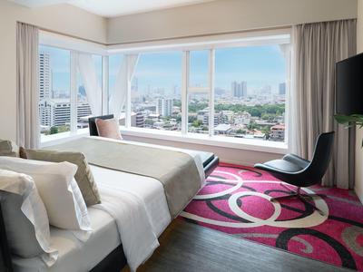 Modernes Schlafzimmer mit großem Fenster, Doppelbett, schwarz-rosa Teppich und Fernseher an der Wand.