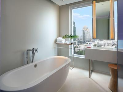 Helles Badezimmer mit freistehender Badewanne, großem Fenster und modernem Waschbecken.