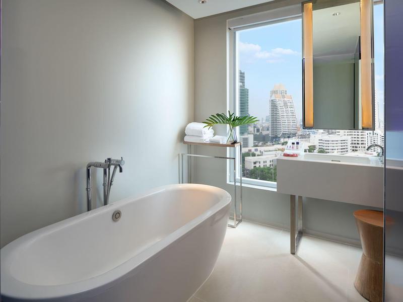 Helles Badezimmer mit freistehender Badewanne, großem Fenster und modernem Waschbecken.