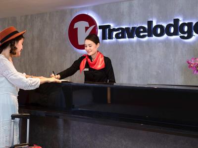 Recepce s recepční a hostem v hotelu Travelodge