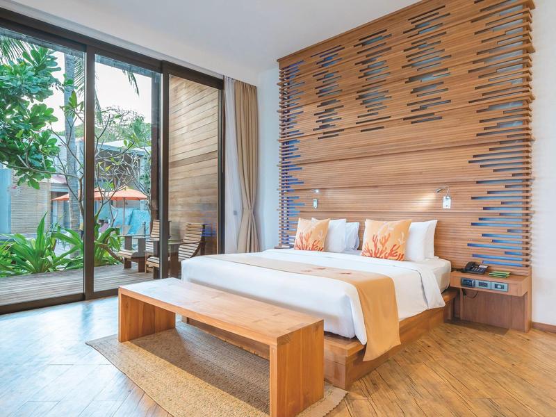 Helles Schlafzimmer mit Holzfußboden, großem Bett, Holzbettkopfteil und bodentiefen Fenstern.