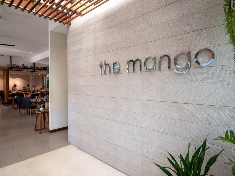 Moderner Empfangsbereich mit heller Wand und grünem Dekor in einem Hotelrestaurant.