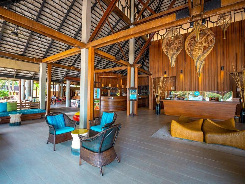 Offener Holzbodenraum mit modernen Sitzmöbeln, Holzbalken und großer Decke aus Holzschindeln.