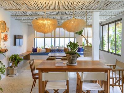 Helles Ess- und Wohnzimmer mit Holzmo?beln, großen Fenstern und zwei Ha?ngelampen aus Naturmaterial.