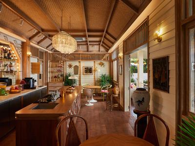 Bar d'hôtel confortable avec plafond en bois, tabourets de bar et lumière naturelle par de grandes fenêtres