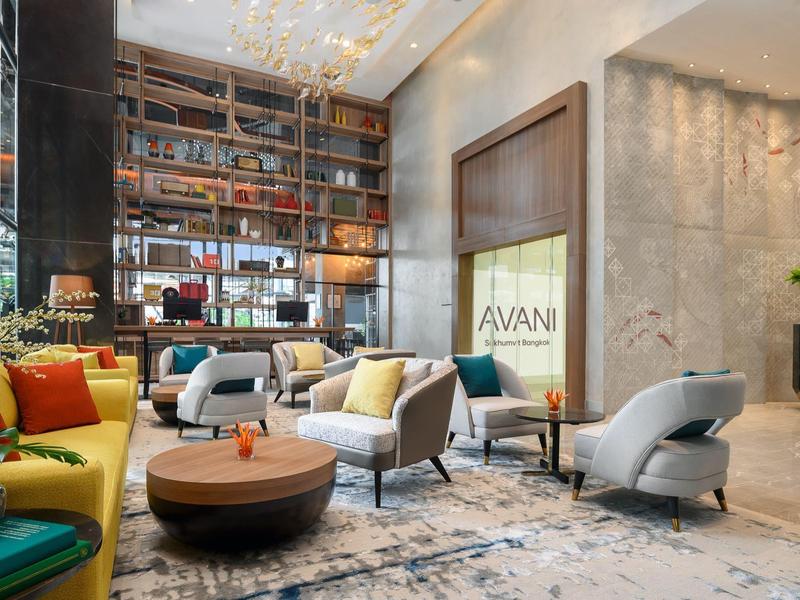 Hall d'hôtel moderne avec sièges confortables et grande bibliothèque murale.