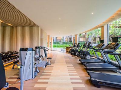 Gimnasio moderno con cintas de correr y pesas en una sala luminosa y espaciosa