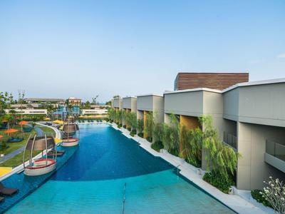 Piscina moderna de hotel con tumbonas y sombrillas en un día soleado