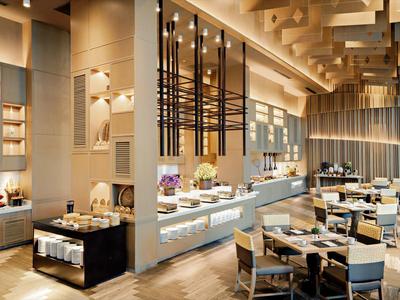 Restaurant d'hôtel moderne avec buffet et ambiance décorative.