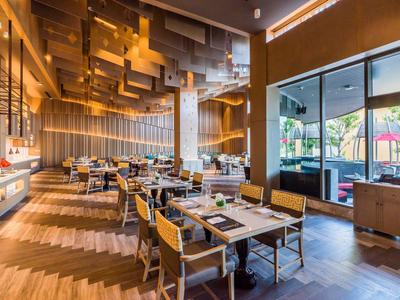 Restaurant aménagé de manière moderne avec parquet, grandes fenêtres et éclairage de plafond attrayant.