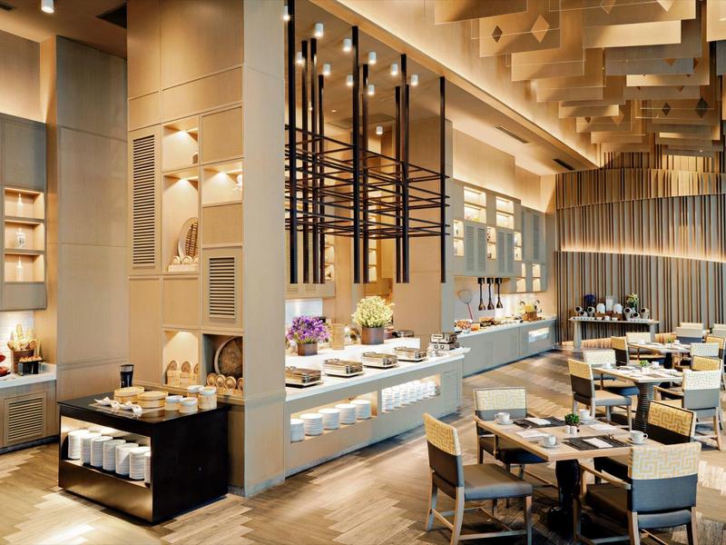Restaurant d'hôtel moderne avec buffet et ambiance décorative.