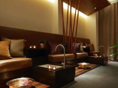 Pohodlná lounge z kůžemi sedačkami, nepřímým osvětlením a teplými dekoracemi.