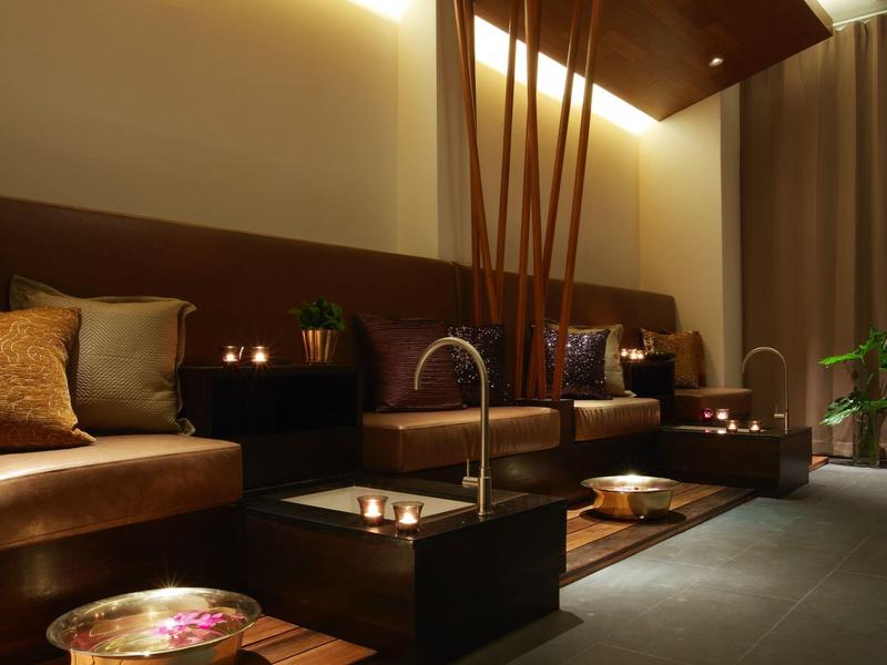 Pohodlná lounge z kůžemi sedačkami, nepřímým osvětlením a teplými dekoracemi.