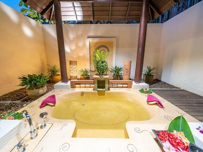 Przytulna wanna na zewnątrz z roślinami i dekoracjami w relaksującej atmosferze.