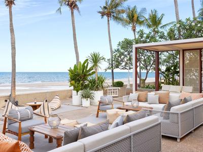 Modern terrace with comfortable seating and a view of the beach and sea.