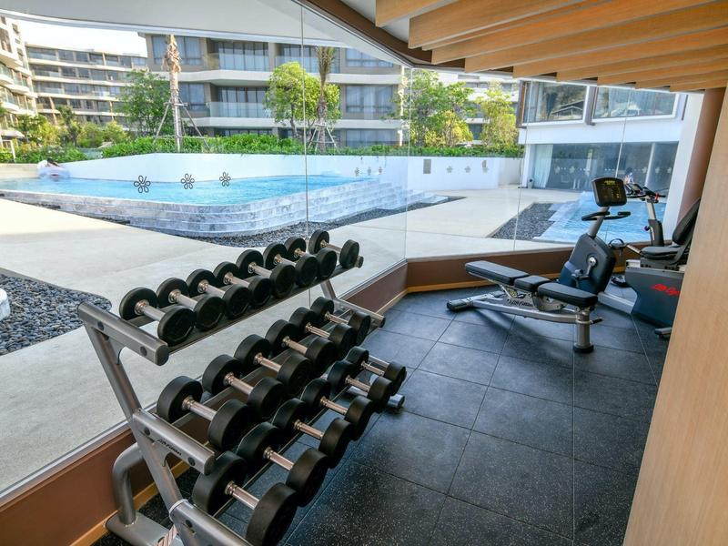 Palestra moderna con manubri e vista su una piscina all'aperto.