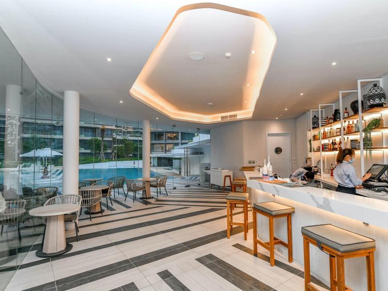 Ristorante moderno dell'hotel con bar, sgabelli e vista sull'area piscina