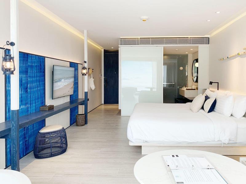 Camera d'hotel moderna con due letti grandi e accenti blu sulle pareti.