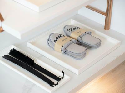 Soft slippers and a black belt in a white drawer in the hotel room.