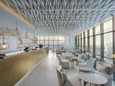 Moderner Hotel-Loungebereich mit hohen Fenstern und hellen Sitzbereichen mit Meerblick.