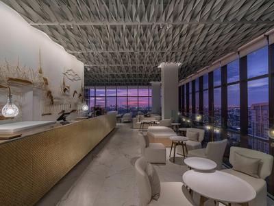 Elegant hotel bar with panoramic windows offers a relaxed evening atmosphere at sunset.