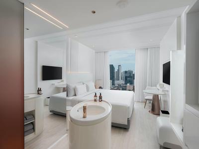 Modern hotel room with city view and bright, minimalist design.
