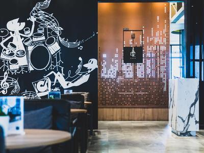 Moderne hotel lounge met zwarte wandkunst en stijlvolle zitplaatsen.