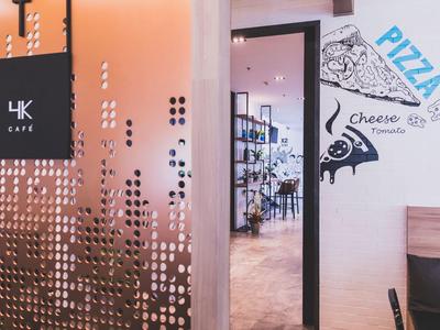 Modern café area with transparent partition and pizza wall decoration