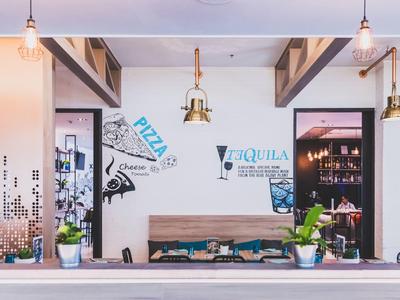 Modern dining area with wooden table, wall decorations, and pendant lights in restaurant