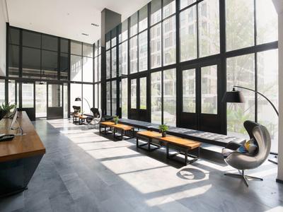 Bright modern waiting area with large windows, benches, and lounge chair.