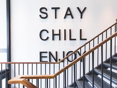 Scala moderna con testo murale 'STAY CHILL ENJOY' in un hotel.