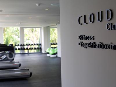 Modern gym with treadmills and weights, 'CLOUD Club' sign on the wall.
