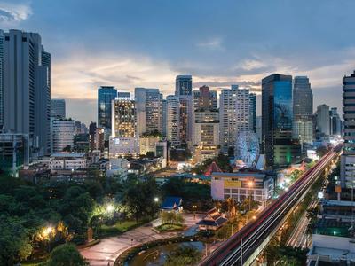 Horizonte urbano al anochecer con rascacielos modernos y luces en las calles.