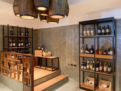 Bodega elegante con estanterías de madera y luz rústica en el techo de un hotel.