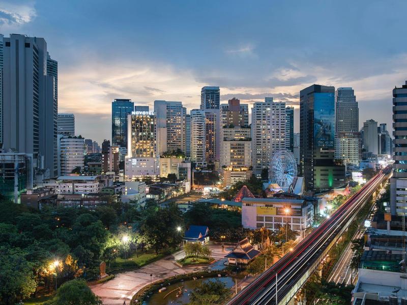 Horizonte urbano al anochecer con rascacielos modernos y luces en las calles.