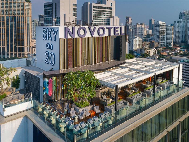 Terraza en la azotea de un hotel con asientos y vista del paisaje urbano.