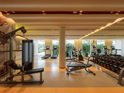 Modernes Fitnessstudio mit Trainingsgeräten und Hanteln in einem Hotel.