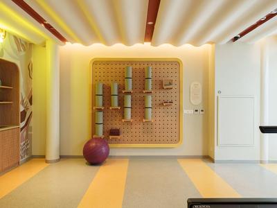 Heller Fitnessraum mit Yoga-Matten, Gymnastikbällen und Holzregalen für Hotelgäste.