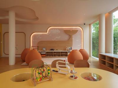 Hell eingerichteter Raum mit Spielzeug, Pillows und großer Fensterfront in einem Hotel.