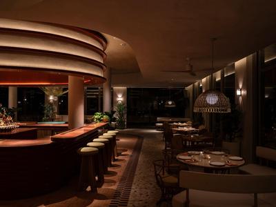 Gemütliche Hotelbar mit warmem Licht, Rundtheke und eleganter Sitzordnung.