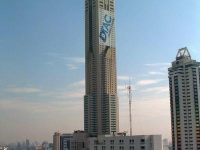 Alto edificio moderno dell'hotel con linee pulite e logo sullo sfondo del cielo azzurro.